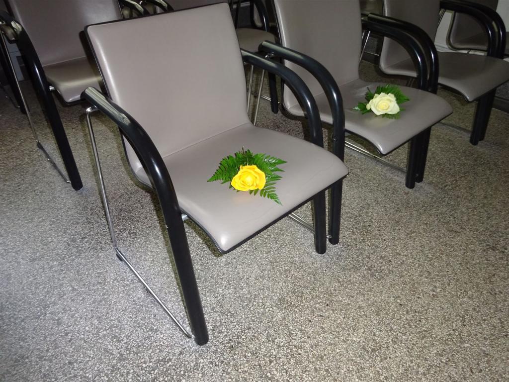 Rosen auf Stühlen in Trauerhalle